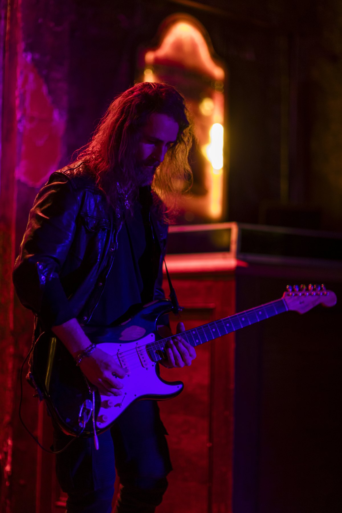 Cash Ulrich playing under red stage lighting